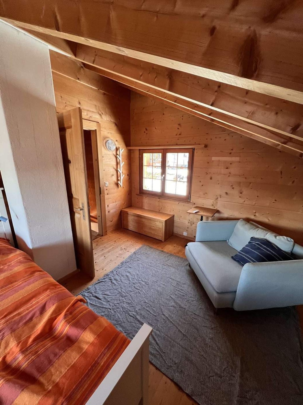 Attic room with sofa and double bed