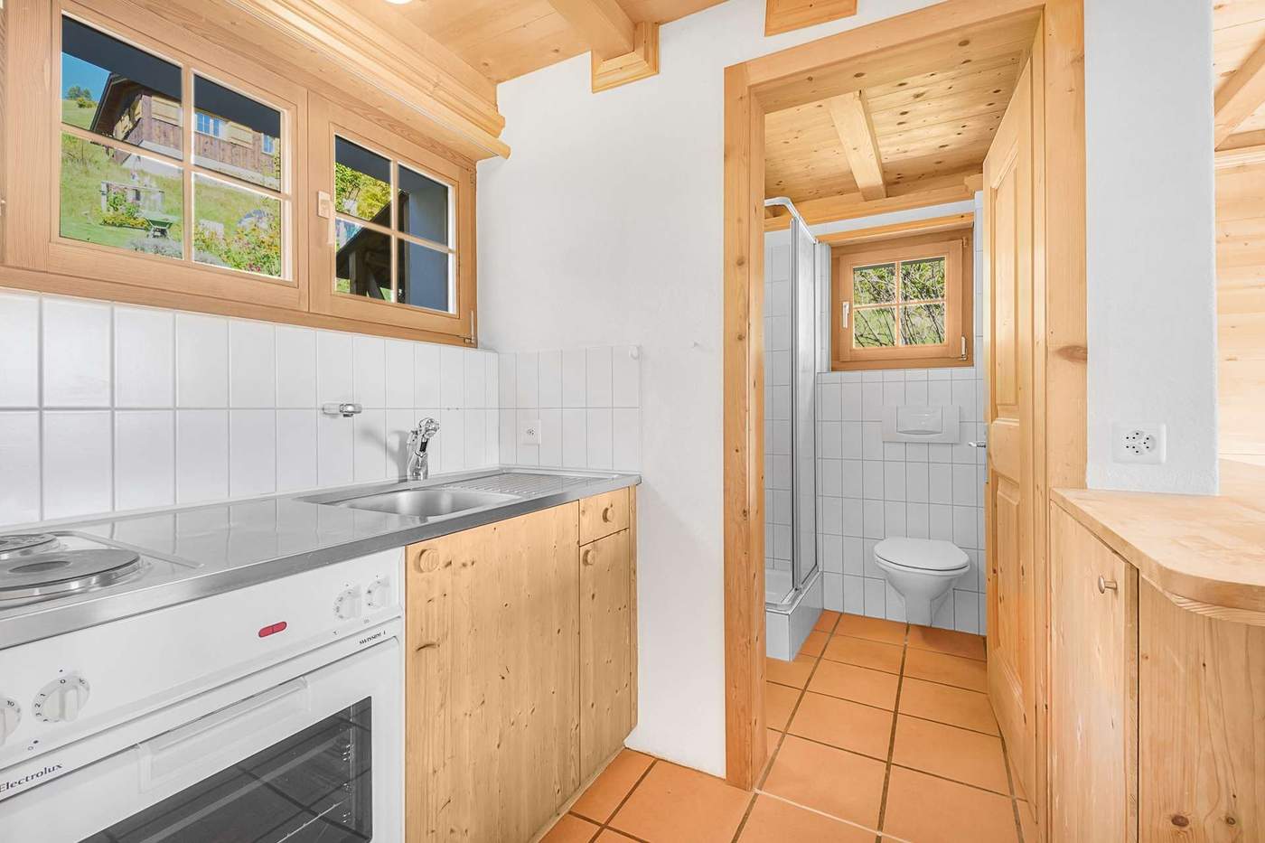 Kitchen with electric hob and view into the bathroom